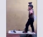 Un enfant en équilibre sur une planche met des bols sur sa tête