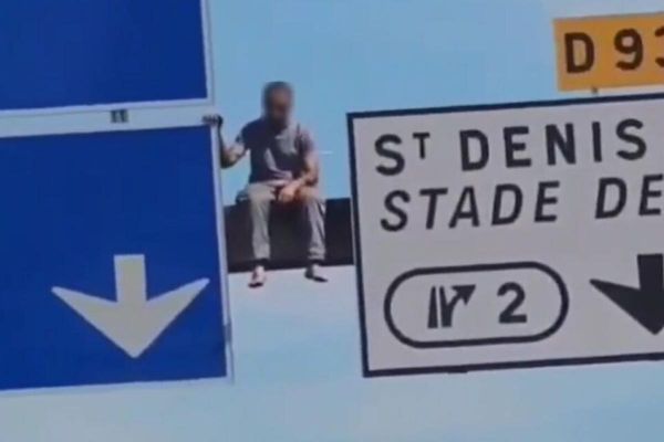 Un homme grimpe sur un panneau de signalisation et paralyse l'autoroute
