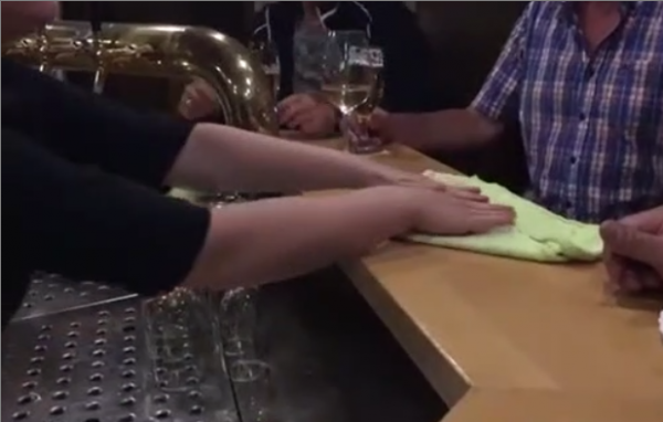 Un homme fait un petit tour de magie à la serveuse d'un bar
