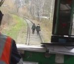 Un conducteur de train fait peur à des filles sur une voie ferrée