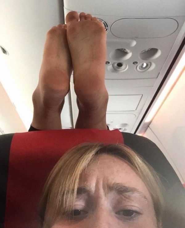 Une femme partage un selfie avec des pieds du passager sur son repose-tête