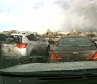 La dahcam d'une voiture sur un parking filme le passage d'une tornade